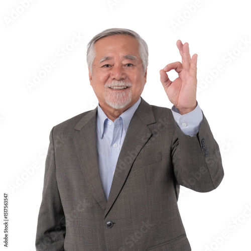 Smiling senior Asian businessman in suit showing OK hand sign, confident and positive gesture, successful older male professional, isolated on a transparent background, business concept