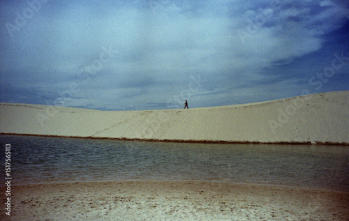 A person walking on top of a sand dune photo