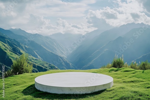 Circular grass podium offers panoramic mountain views on a serene hilltop during a clear day with soft sunlight enhancing the natural landscape