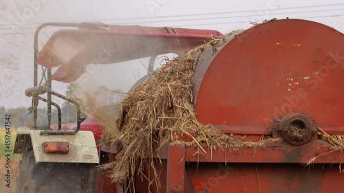 A tractor-powered thresher, a farm machine used to separate grain from stalks and husks after harvesting
