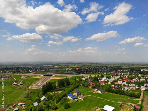 Villages on the outskirts of the city, in a mountainous area. Drone view, spring time, partly cloudy