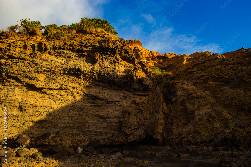 Obraz premium Layers of rocks and stones in the Piha beach cliff walls in Auckland, New Zealand.