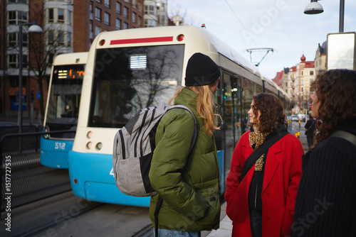 Male and female friends waiting for bus at street