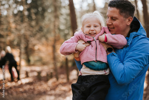 Smiling father spending leisure time with daughter in nature