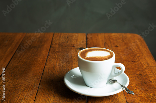 Cup of coffee with spoon kept on wooden table