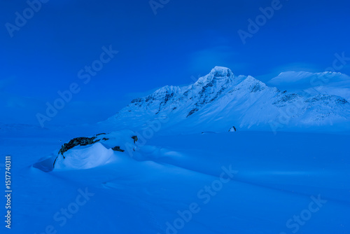 Snow covered mountains against clear blue sky at dusk