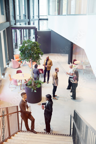 High angle view of male and female business professionals talking with each other at networking event