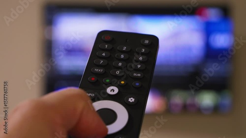 Male hand holding the TV remote control and turn on smart tv. Switching channels. High quality 4k footage