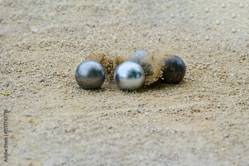 Carta da parati Close-up of petanque precision shooting moment with metal ball hitting target bo