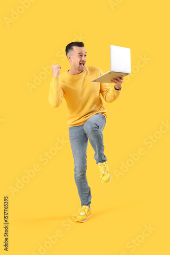 Happy young man with laptop...