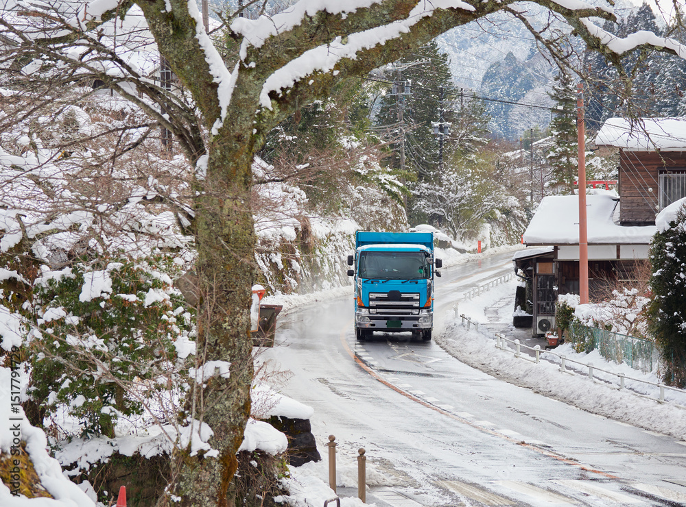 Naklejka premium 観光名所中山道の妻籠宿の古い町並みの雪景色と道路上の大型トラック