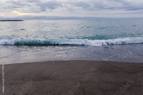 Fototapeta Naklejka Na Ścianę i Meble -  Sea surf waves on a sandy shore in overcast morning