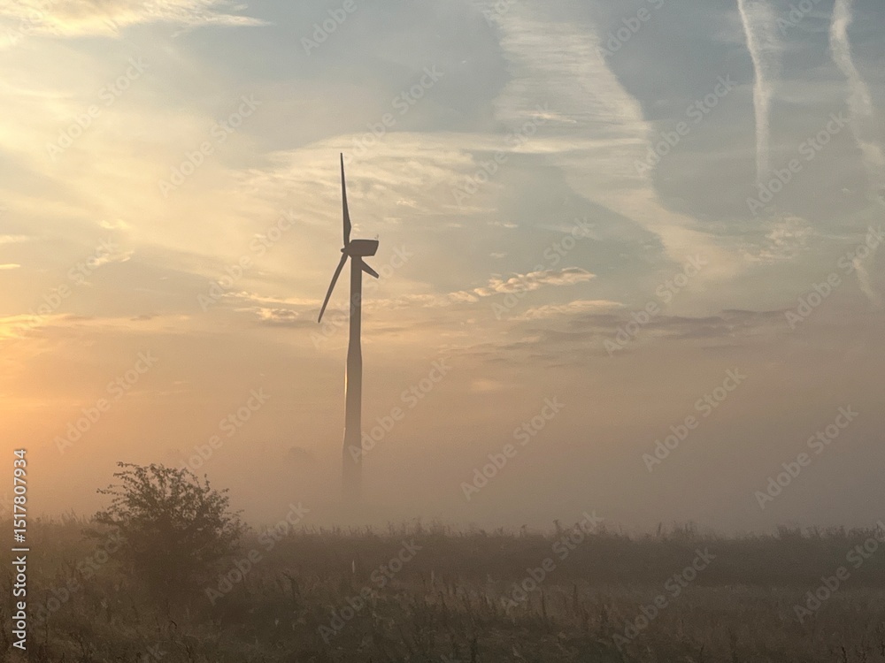 Obraz premium wind turbine in the field in the sunrise a foggy morning