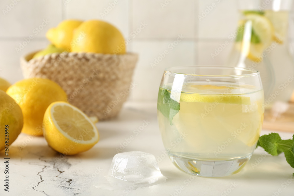 Glass of fresh lemonade with mint and lemons on white table, closeup Glass of fresh lemonade with mint and lemons on white table, closeup