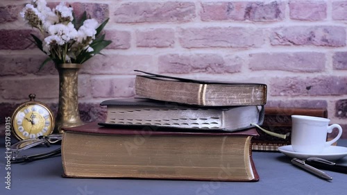 Bible falling for study on gray table with glasses clock and coffee in the morning. Preparation for communion and worship concept. Slow motion