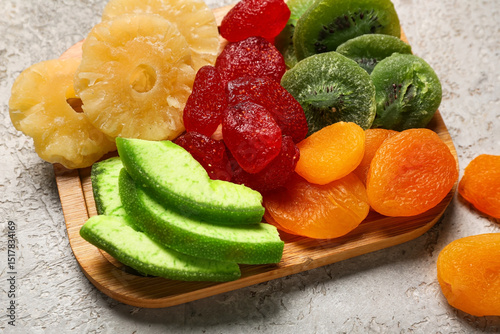 Fototapeta Naklejka Na Ścianę i Meble -  Wooden board with different candied fruits on grey background, closeup