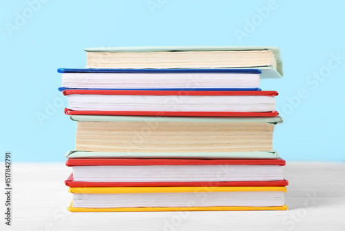 Stacked colorful books on w...
