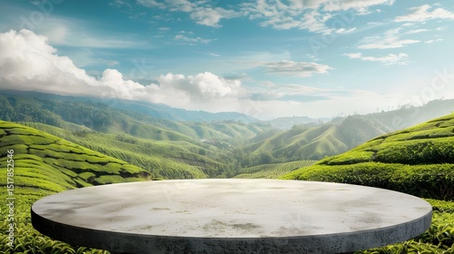 A large, empty circular stone platform sits in a lush green valley. The sky above is clear and blue, with a few clouds scattered throughout. Concept of tranquility and serenity