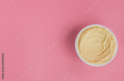 Hummus dip on a pink background photo