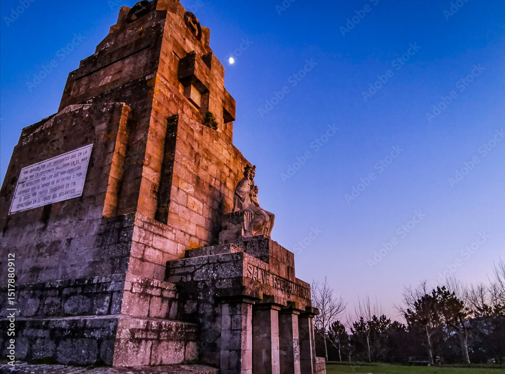 Fototapeta premium Monumento con color anaranjado, al atardecer, con la luna al fondo.