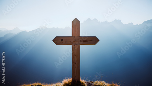 Wooden cross standing on a grassy hill with a backdrop of hazy blue mountains under a clear sky, symbolizing faith and spirituality
