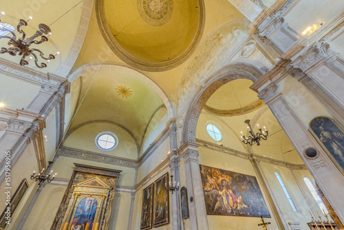 Ferrara, Italy - May 17, 2025: Interior of Saint Christopher church of Charterhouse of Ferrara with vaulted ceiling, crucifix, altar, paintings and wooden pulpit, creating a serene atmosphere of faith photo