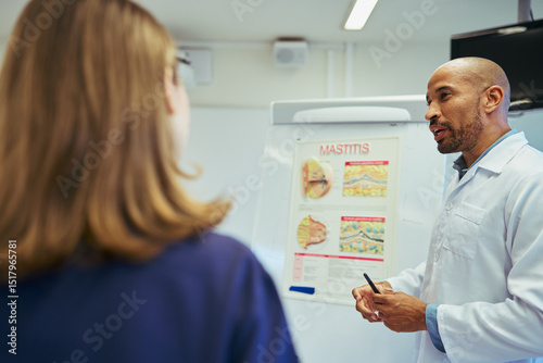 Doctor explaining mastitis to nurse in hospital room