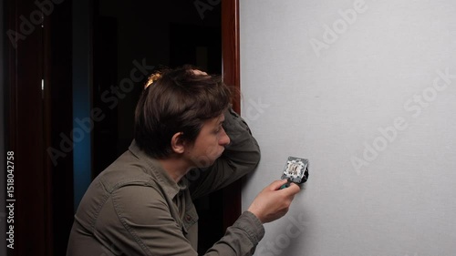 A man does not know how to fix the electrical wiring, a switch at home