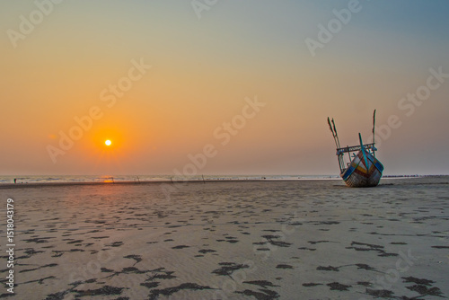 Traditional Sampan Boat at Sunset on Sandy Beach. Cox's Bazar, Bay of Bengal, Bangladesh