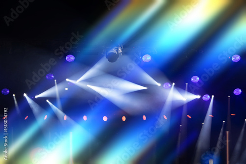 A stage with many lights and a spotlight. The lights are blue and red