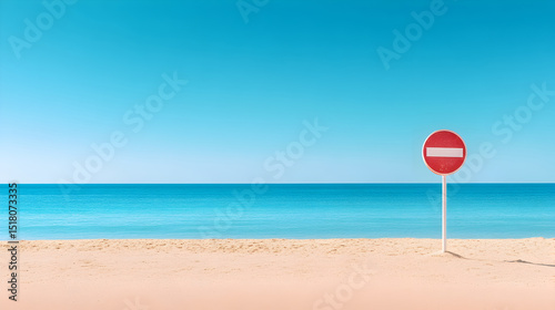 Red no entry sign stands on sandy beach with calm turquoise ocean and clear blue sky, creating a serene and tranquil coastal atmosphere. Selective focus