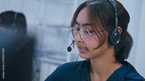 Attractive Young indian businesswoman with headset, making video call in office. Asian call center female agent using computer working on online customer service support helpdesk talking to client.