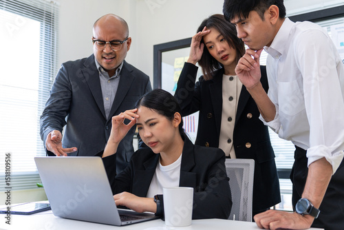 Diverse Asian business team stressed over financial statistics analysis problems. Group of business team meeting discussing various topics. Organizational concept in office.