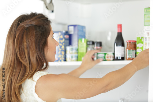 rear view of beautiful woman at her food cupboard