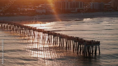Aerial view of the Jacksonville Beach Pier in north Florida during a summer sunset.