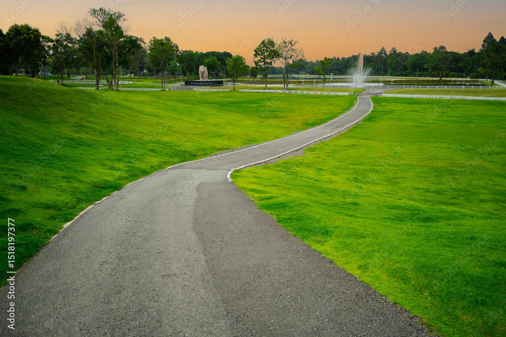 Obraz premium Beautiful park suitable for exercise and relaxation. Morning atmosphere, green lawn, mountain view and fresh air. CMPAO Chiang Mai Garden.