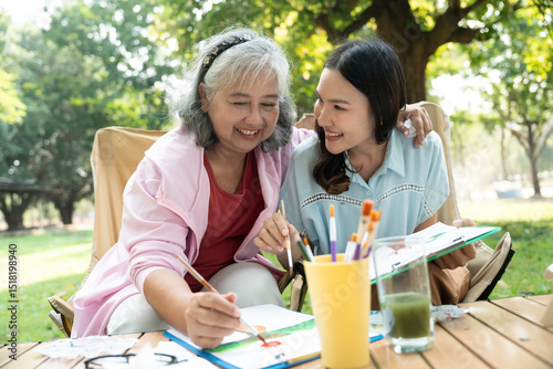 A senior mother and her daughter spend quality time together outdoors, sharing a tender moment filled with love and care. Their strong family bond reflects warmth and togetherness in every embrace
