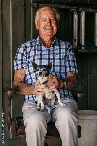 Elderly man sitting with his little dog.