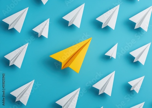 A standout yellow paper airplane among many white ones on a blue background, symbolizing uniqueness and leadership. photo