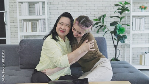Daughter hugs her mother on the sofa at home
