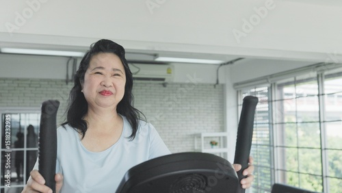 elderly woman exercising with elliptical trainer