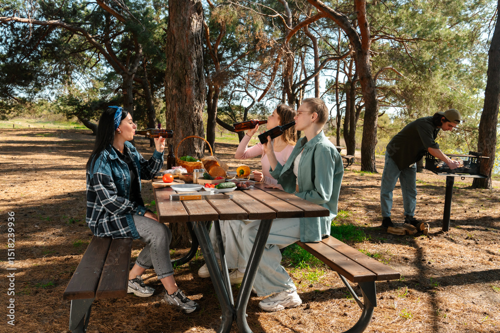 Obraz premium Friends Enjoying a Relaxing Picnic in the Forest