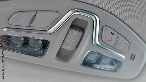 Modern car overhead console with sunroof, lighting, and SOS buttons, showcasing luxury interior details and advanced ergonomic design.