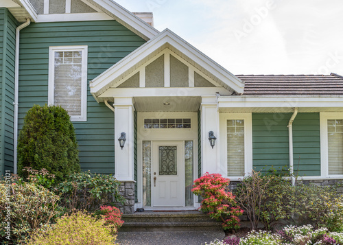 Entrance of grey painted luxury house in spring with stair steps and nice landscape in Vancouver, Canada, North America. Day time on May 2025.