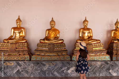 Tourists look at golden Buddha in Temple , Bangkok Thailand	