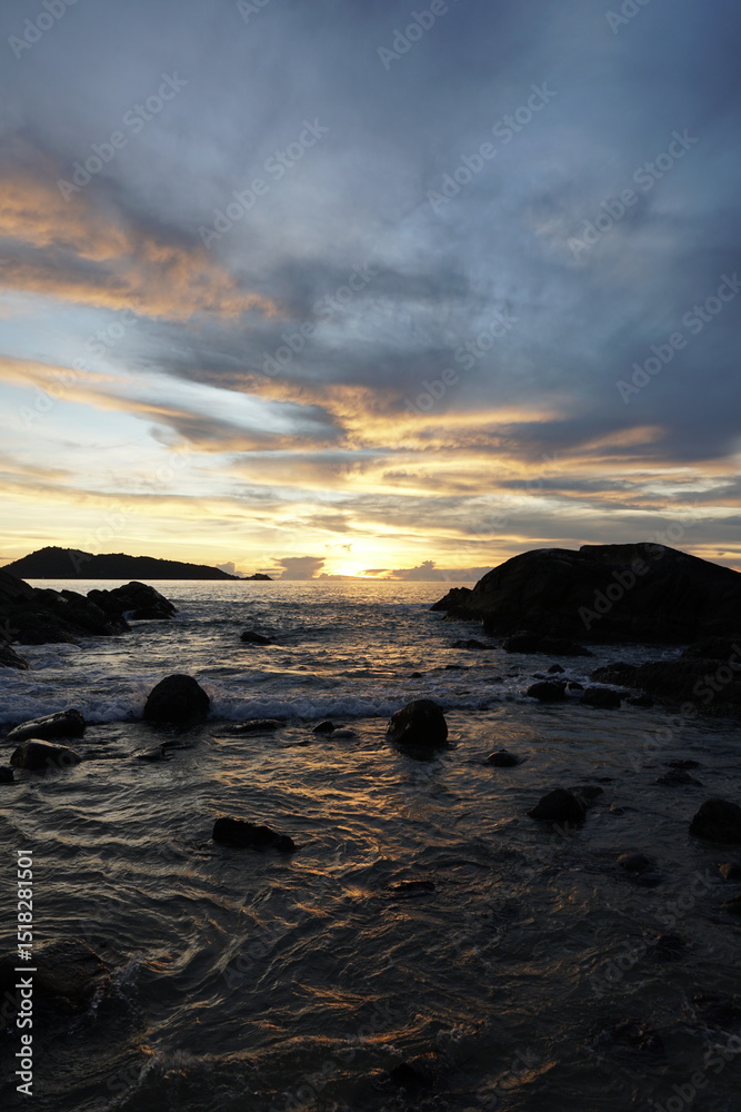 Serene Sunset Over Rocky Shoreline with Gentle Waves and Reflective Water Surface Serene Sunset Over Rocky Shoreline with Gentle Waves and Reflective Water Surface