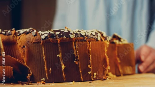 Waviness effect of The woman cuts the chocolate cake with a knife. On the background are purges of Easter made of paper. Macro and slider shooting