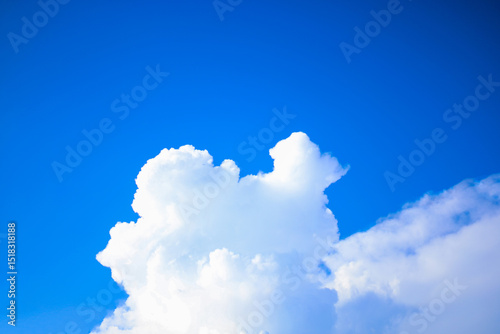 White clouds float quietly amidst a clear blue sky. This simple yet peaceful moment perfectly captures the serene beauty of nature, evoking both imagination and peace at the same time.