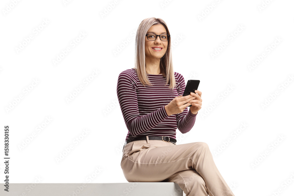 Naklejka premium Woman sitting on a wall and using a mobile phone