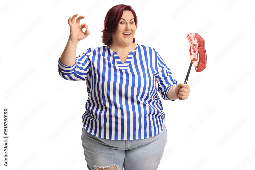 Naklejka premium Overweight woman holding a raw meat steak and gesturing ok sign